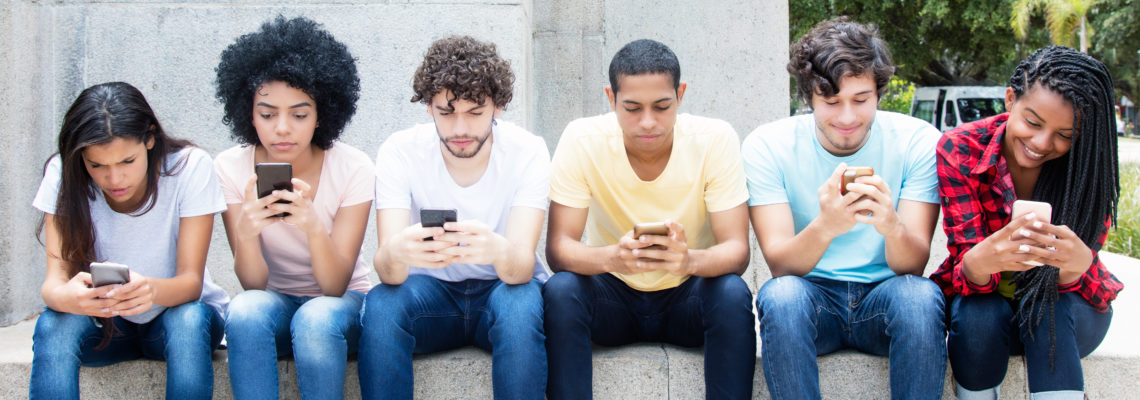 Grosse Gruppe Jugendlicher spielt mit Handy