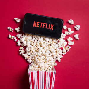 LONDON, UK - MAY 14 2020: Netflix logo on a smartphone with popc
