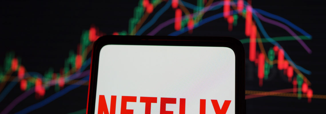 Netflix logo and stock index is seen on display screen. It is an