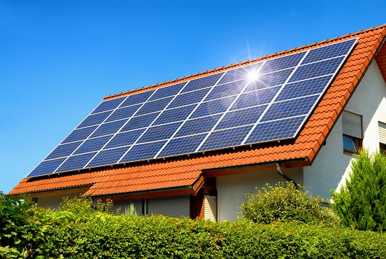 Solaranlage auf einem Hausdach unter dem strahlend blauen Himmel, mit der Reflektion der Sonne