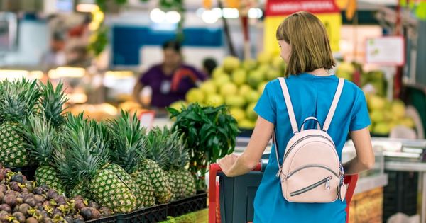 Frau steht am Obst im Supermarkt