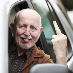 senior im auto zeigt stinkefinger