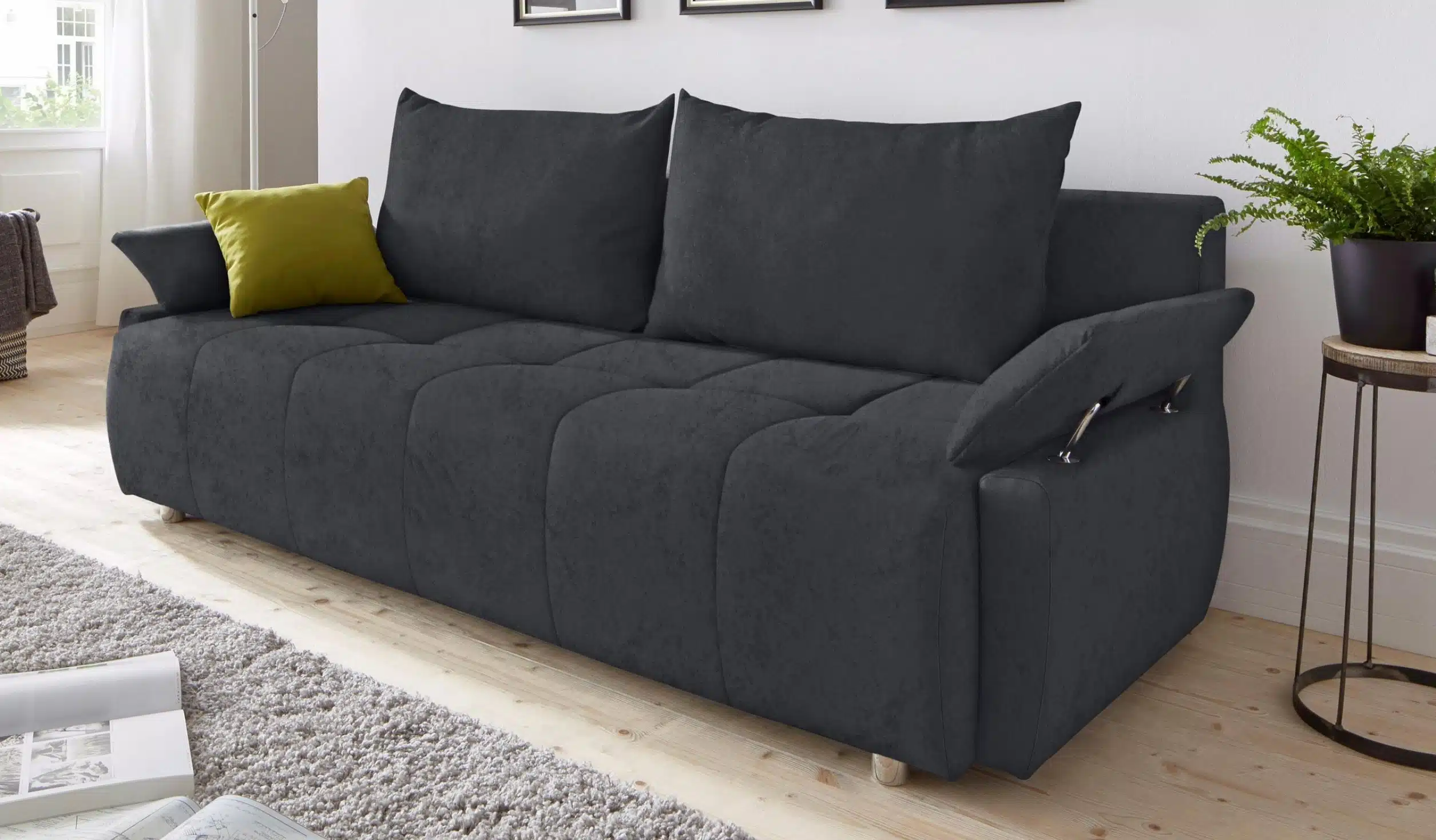 Ein Schlafsofa aus der OTTO Collection, in dunklem Grau, mit bequemen Kissen und modernem Design. Der Bezug ist weich und das Sofa verfügt über verstellbare Armlehnen.