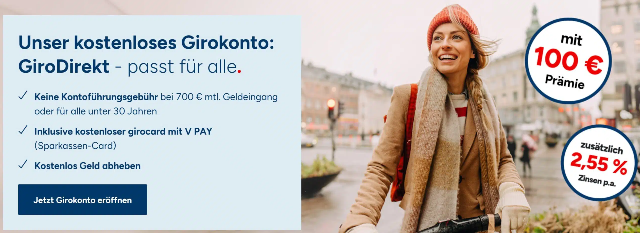 Werbebanner der 1822direkt Bank für das Girokonto GiroDirekt. Links steht der Text 'Unser kostenloses Girokonto: GiroDirekt - passt für alle.' mit Vorteilen wie keiner Kontoführungsgebühr ab 700 € Geldeingang, kostenloser Sparkassen-Card und kostenlosen Barabhebungen. Rechts ist eine lächelnde Frau mit roter Mütze und Schal auf einem Fahrrad in einer Stadt zu sehen. Zwei runde Störer weisen auf '100 € Prämie' und 'zusätzlich 2,55 % Zinsen p.a.' hin.