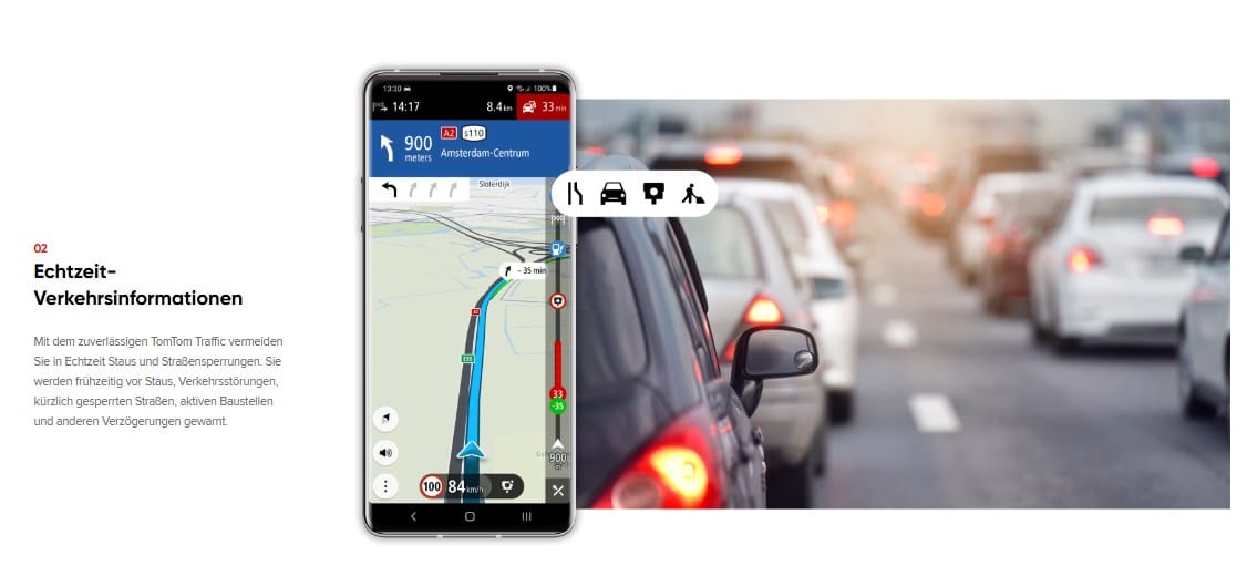Screenshot der TomTom GO Navigation App, die Echtzeit-Verkehrsinformationen anzeigt, mit einer Route und einer Warnung vor Verkehrsstaus. Das Bild zeigt das Navigationsgerät auf einem Smartphone, während im Hintergrund eine Autoschlange im Verkehr zu sehen ist. Dazu der Text: ‚Echtzeit-Verkehrsinformationen mit TomTom Traffic‘.