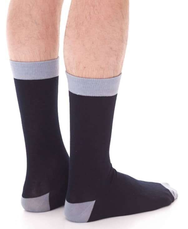 Zwei Männerbeine von hinten, an deren Füßen lange Socken sind