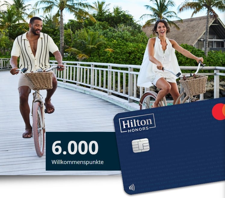 Zwei Menschen auf Fahrrädern an einer Strandpromenade. Darunter ein Teil der Hilton Honors Kreditkarte und links daneben 