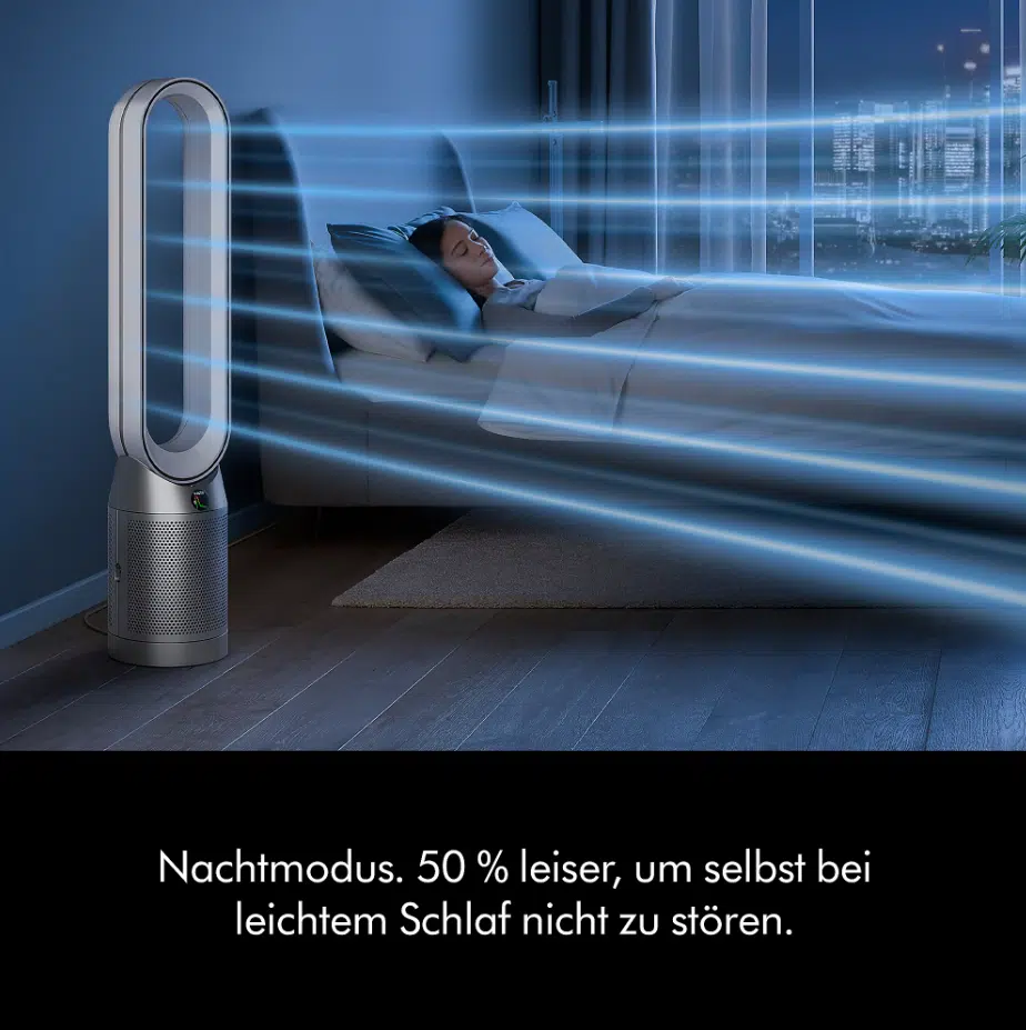 Dyson TP11 Luftreiniger & Ventilator arbeitet in einem Schlafzimmer, während eine Frau im Bett schläft.