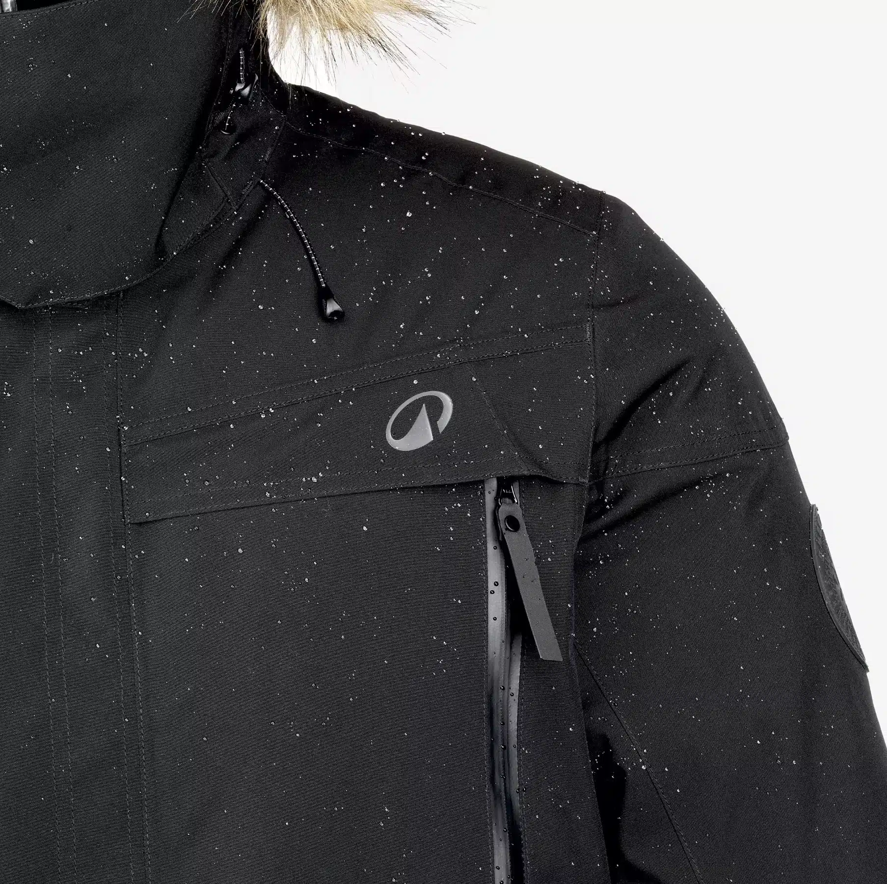 Ausschnitt des Herren-Parkas von Quechua bei Decathlon, man sieht linke Schulter, die Wasser / Schnee abweist