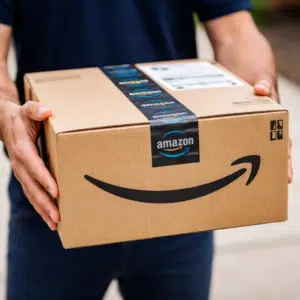 Amazon: Mindestbestellwert für kostenlosen Versand erhöht - im Bild Hände eines Lieferanten mit Amazon-Paket