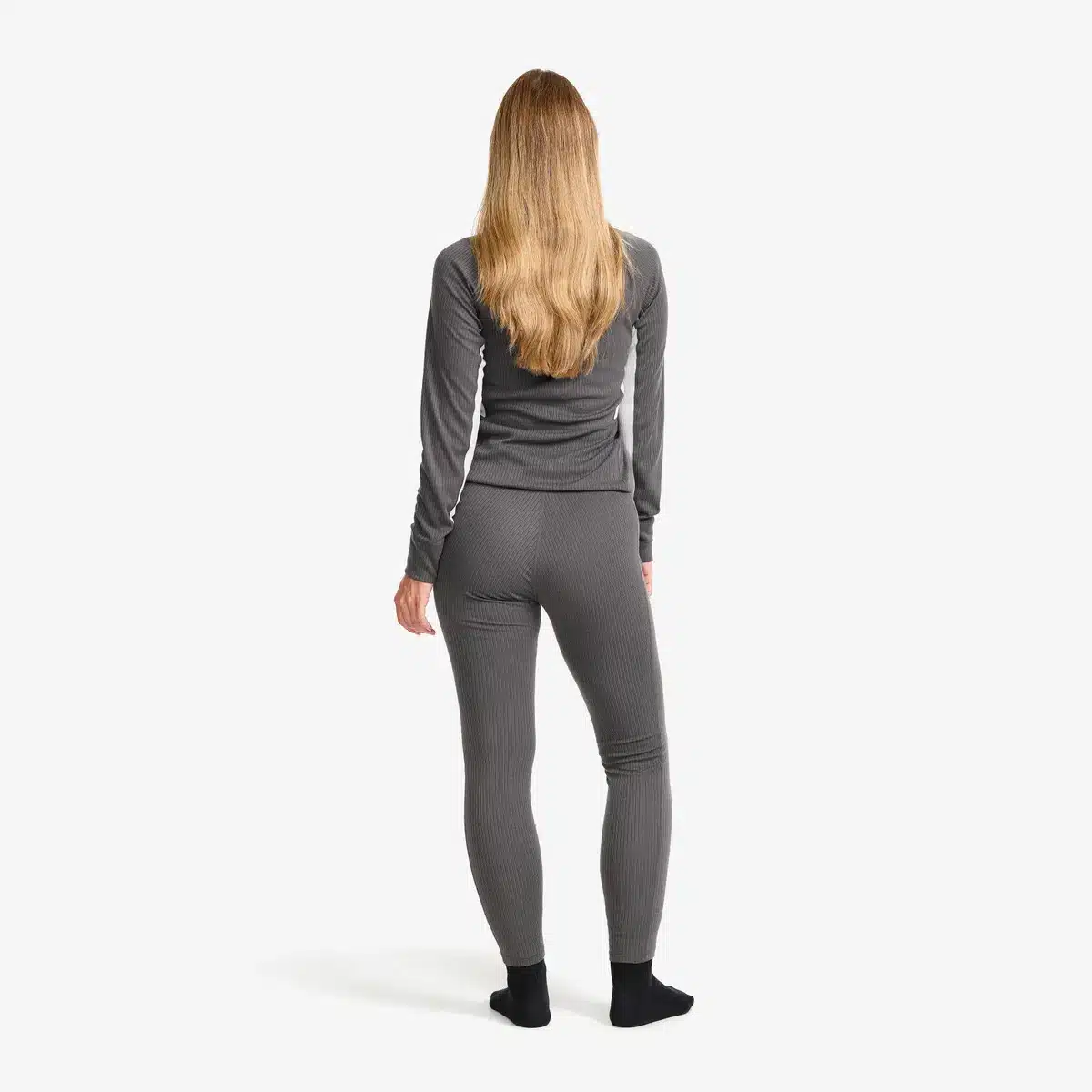 Blonde Dame, die die RevolutionRace Movement Pants trägt. Ansicht von hinten.