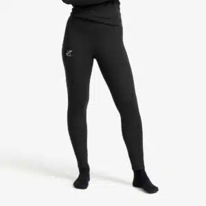 Untere Hälfte einer Dame, die schwarze Leggings trägt, nämlich die RevolutionRace Movement Pants