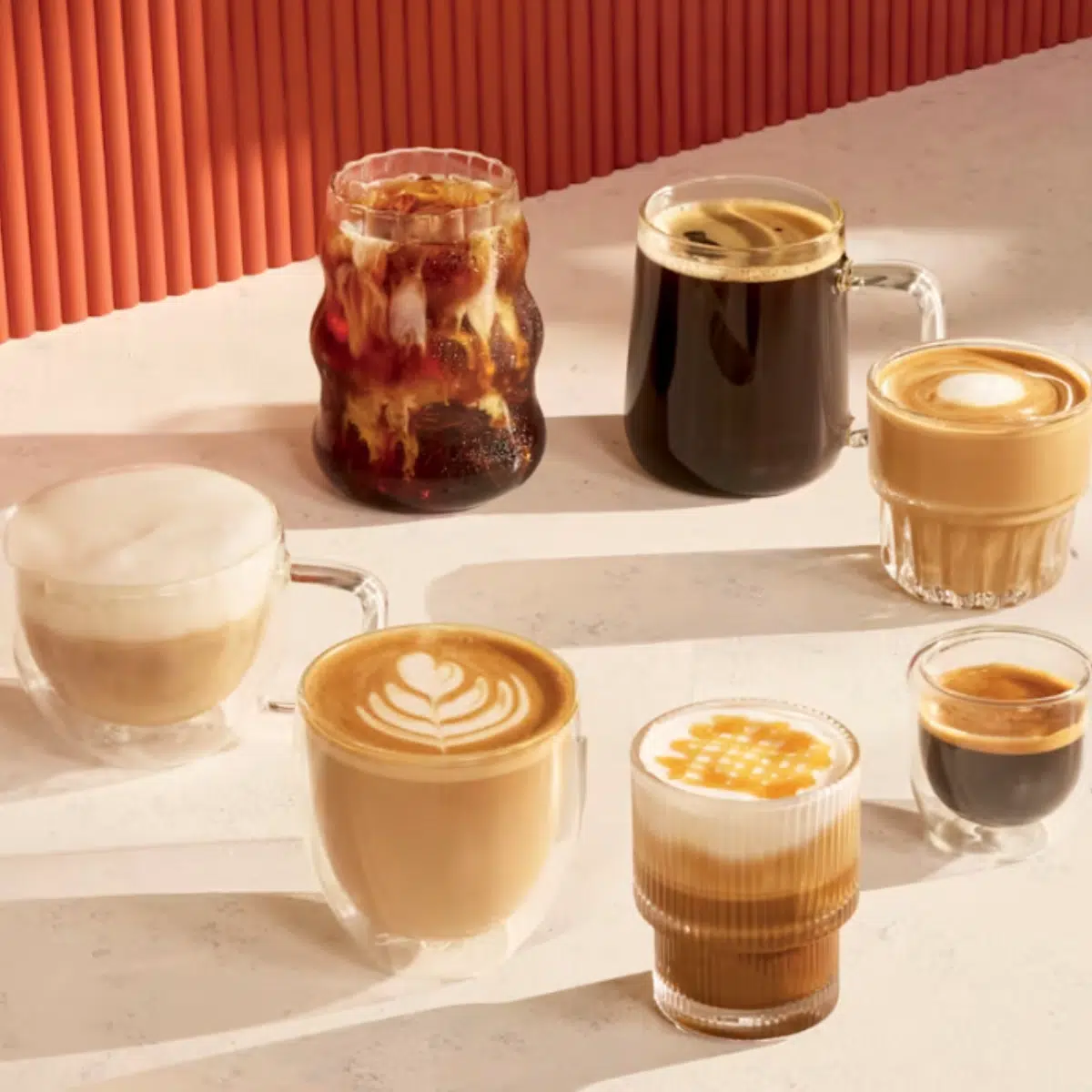 Ninja Luxe Café MINI Plus Kaffeemaschine ES352EU: eine Vielzahl unterschiedlicher Kaffee-Zubereitungen nebeneinander auf einem Tisch