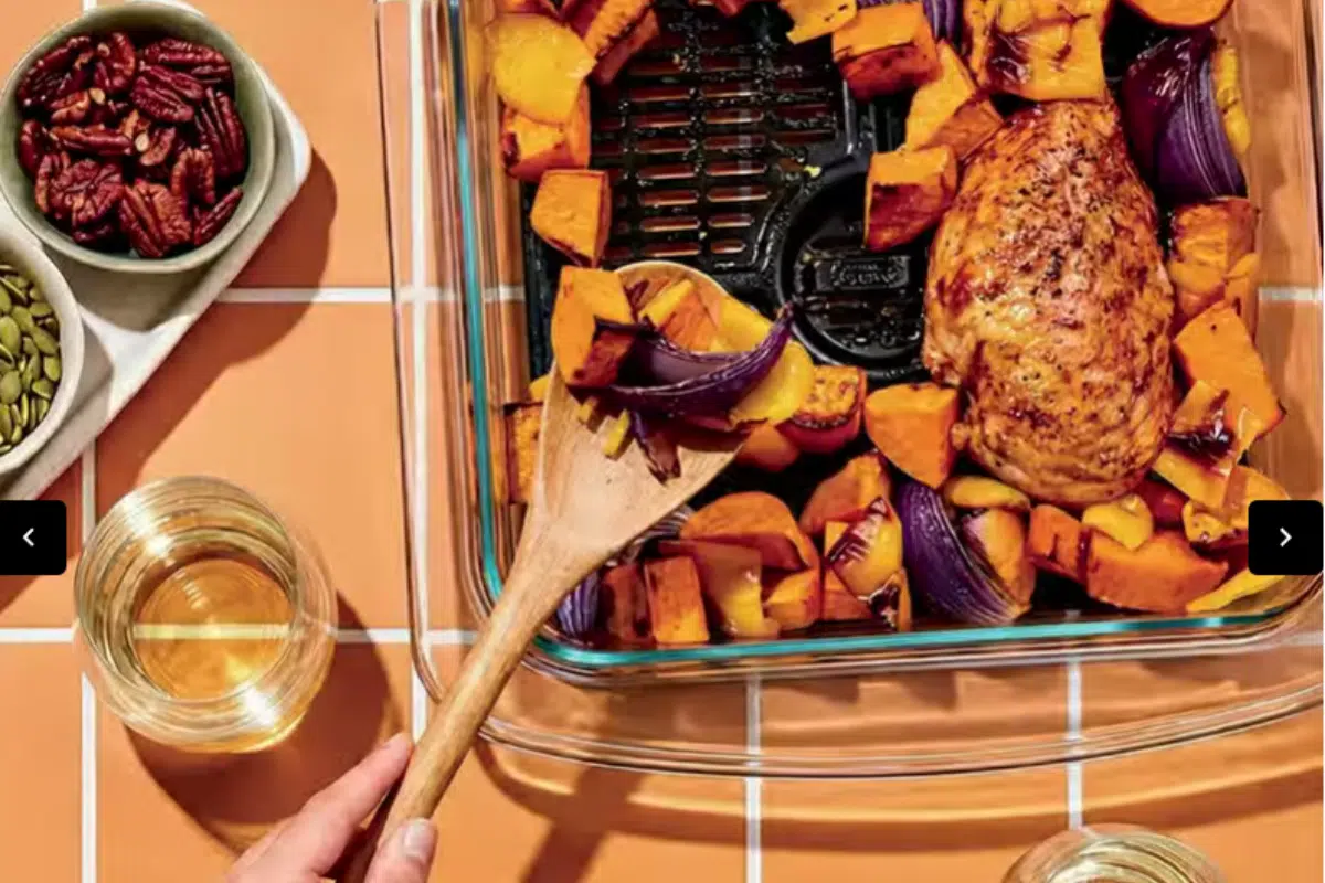 Ninja Crispi Microwave: Die Glasschüssel mit Hähnchenschenkel und Kartoffeln auf einer Küchenanrichte zwischen anderen Speisen